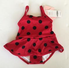 Here is a cute one-piece swimsuit from the Gymboree 2009 Flitter Flutter layette line New with tags. Choose available sizes from the drop down menu. Flitter Flutter Polka Dot Skirted One-Piece Swimsuit - 80% nylon / 20% spandex swimsuit is fully lined and has allover black polka dots, an attached skirt, a bow in back, a built-in liner / swim diaper cover, and sunscreen protection (screens out 99% of UVB/UVA rays). Color: red. International Buyers - Please Note: Import duties, taxes and charges a Summer Sleeveless Tankini For Playtime, Fitted Beachwear Tankini For Playtime, Sleeveless Summer Tankini, Cute Red Swimwear For Playtime, Summer Polka Dot Tankini For Swimming, Polka Dot Tankini For Summer Swimming, Cute Fitted Sleeveless Tankini, Polka Dot Swimwear For Spring Swimming, Cute Fitted Tankini For Swimming