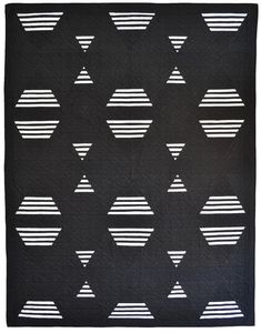 a black and white quilt with geometric shapes on the front, along with lines in the middle