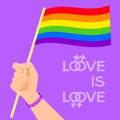 a hand holding a rainbow flag with the words love is love