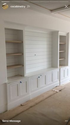 an empty room with built in bookshelves and cabinets