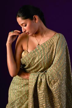 Light green saree in cotton zari silk base embellished with zari stripes and pitta work. Paired with strap sleeves padded blouse with a ruching texture all over.
Components: 2
Pattern: Zari Striped
Neckline: Square
Sleeve Type: Strap Sleeves
Fabric: Cotton Zari Silk
Color: Green
Other Details: 
Attached inner lining
Padded blouse
Length: 
Blouse: 14.5inches
Model Height: 5ft 9inches, wearing size M
Occasion: Mehendi and Haldi, Sangeet - Aza Fashions