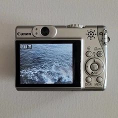 a digital camera sitting on top of a white wall