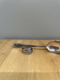 a silver spoon sitting on top of a wooden table