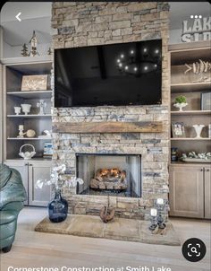 a living room with a stone fireplace and entertainment center