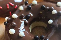 chocolate donuts with white and black sprinkles are on a wooden table