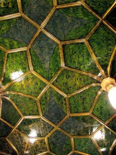 the ceiling is covered in green and gold tiles with light bulbs on each side of it