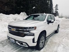 a white truck is parked in the snow