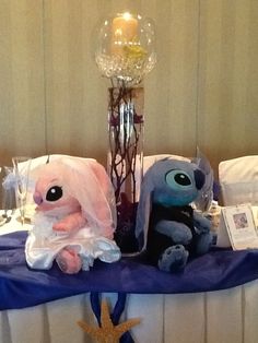 two stuffed animals sitting on top of a table