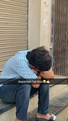 a man is sitting on the steps with his head in his hands and looking down