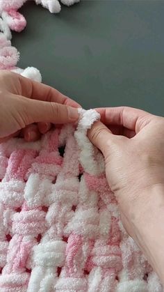 someone is crocheting a pink and white blanket