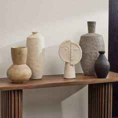 several different vases are sitting on a shelf