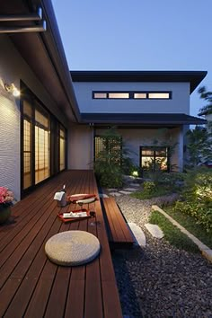 a modern house with wooden decking and outdoor furniture