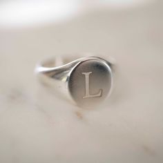 .925 Sterling Silver Round Signet Ring. 9mm x 11mm Perfect for him or for her. Wear on any finger! I like to wear mine on my pinky. Happy to offer custom engraving options. Up to three letters. Please note engraving in the comments at check out. Please see photos for different font options. *For engraving please allow an additional 1 - 3 days for processing* Made in California. Worn everywhere. Classic Signet Ring Stamped 925, Classic 925 Stamped Round Band Signet Ring, Classic Anniversary Initial Ring Stamped 925, Sterling Silver Oval Initial Ring For Gift, Sterling Silver Initial Ring With Engraving Option, Classic Wedding Signet Ring Stamped 925, Classic Oval Sterling Silver Initial Ring, Oval Sterling Silver Stamped Rings, Oval Initial Ring In White Gold And Sterling Silver