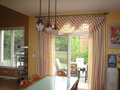 a dining room table with chairs and a chandelier hanging from it's ceiling