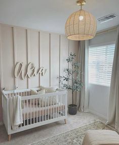 a baby's room with a white crib and wooden paneling on the wall