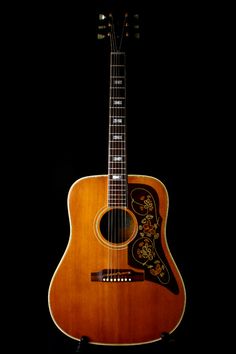 an acoustic guitar is shown against a black background