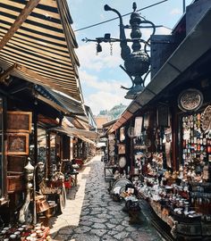 an alley way with lots of items on the walls and in front of it is a lamp post