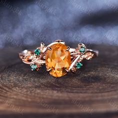 an orange stone surrounded by green and white stones sits on top of a wooden surface