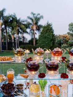 an assortment of teas and desserts on a glass table