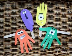 three handprinted paper puppets sitting on top of a wicker basket