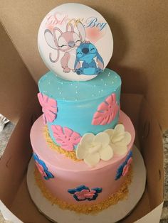 a pink and blue cake in a box