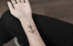 a woman with a small anchor tattoo on her wrist