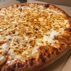 a large cheese pizza sitting in a box