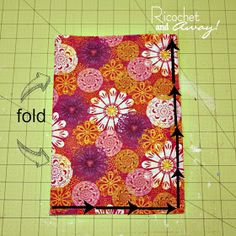 a piece of fabric with flowers on it next to a ruler and cutting board that says fold