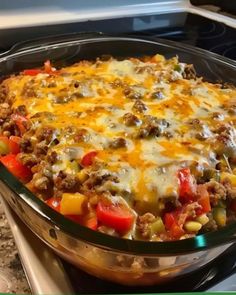 a casserole dish with meat, vegetables and cheese in it on the stove