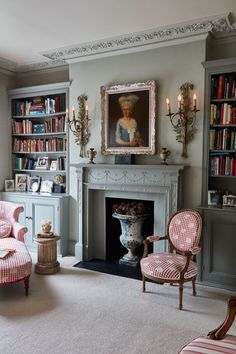 a living room filled with furniture and a fire place in front of a book shelf