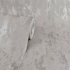 a roll of tape sitting on the side of a wall next to a concrete floor