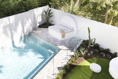 a small backyard with a pool and white furniture