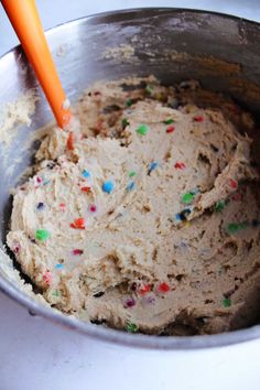 a metal bowl filled with batter and sprinkles