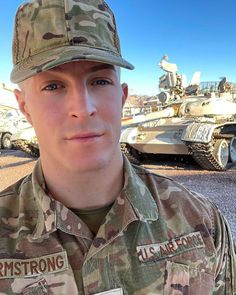 a man in uniform standing next to tanks