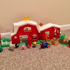 a toy farm set with animals and horses on the ground next to a wall in a room