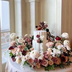 a table topped with a white cake covered in lots of flowers