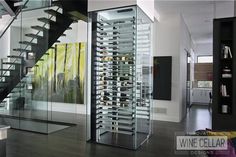 a living room filled with lots of furniture and a spiral stair case next to a glass wall