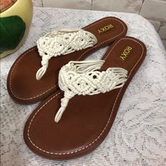 a pair of brown and white sandals sitting on top of a table