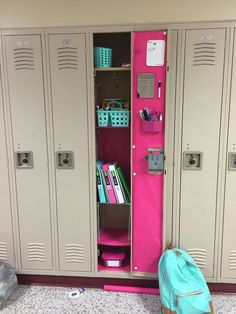 two lockers are shown with pink walls and blue bags on the floor next to them