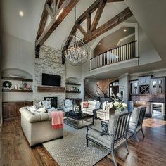 a living room filled with lots of furniture and a chandelier hanging from the ceiling