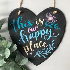 this is our happy place hanging slate heart sign with flowers and leaves on the front