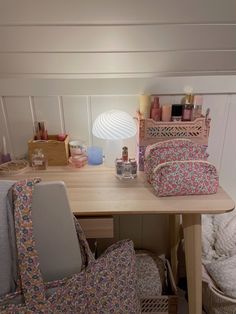 a desk with many items on it and a lamp in the corner next to it