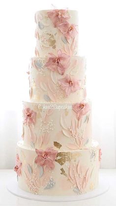 a three tiered wedding cake with pink flowers and leaves on the top, in front of a white background