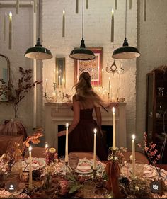 a woman standing in front of a table with candles