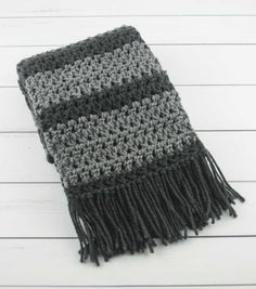 a gray and black crocheted scarf on a white wooden background with text overlay that says, free crochet pattern