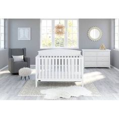 a white crib in a room with gray walls