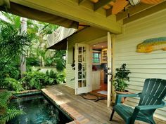 a green chair sitting on top of a wooden deck next to a small swimming pool