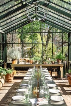 a long table is set with plates and glasses in the middle of an enclosed area