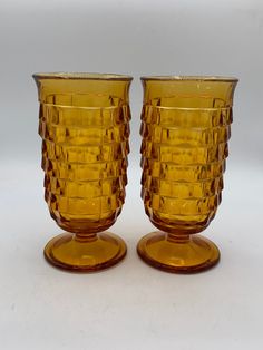 three yellow glass cups sitting next to each other