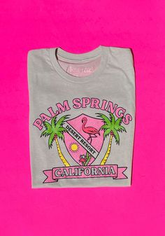 Welcome to Palm Springs, the original Desert Resort. Home to midcentury kitsch and crystalline pools, your perfect summer getaway awaits. Unisex tee in Heather Cement. 52% Cotton, 48% Polyester. Featuring pink glitter and souvenir style graphics. Model wears size Medium. Resort Home, Palm Springs Bachelorette, Desert Resort, Glitter Tee, Palm Spring, Flamingo Shirt, Palm Springs California, Spring Photos, Summer Getaway